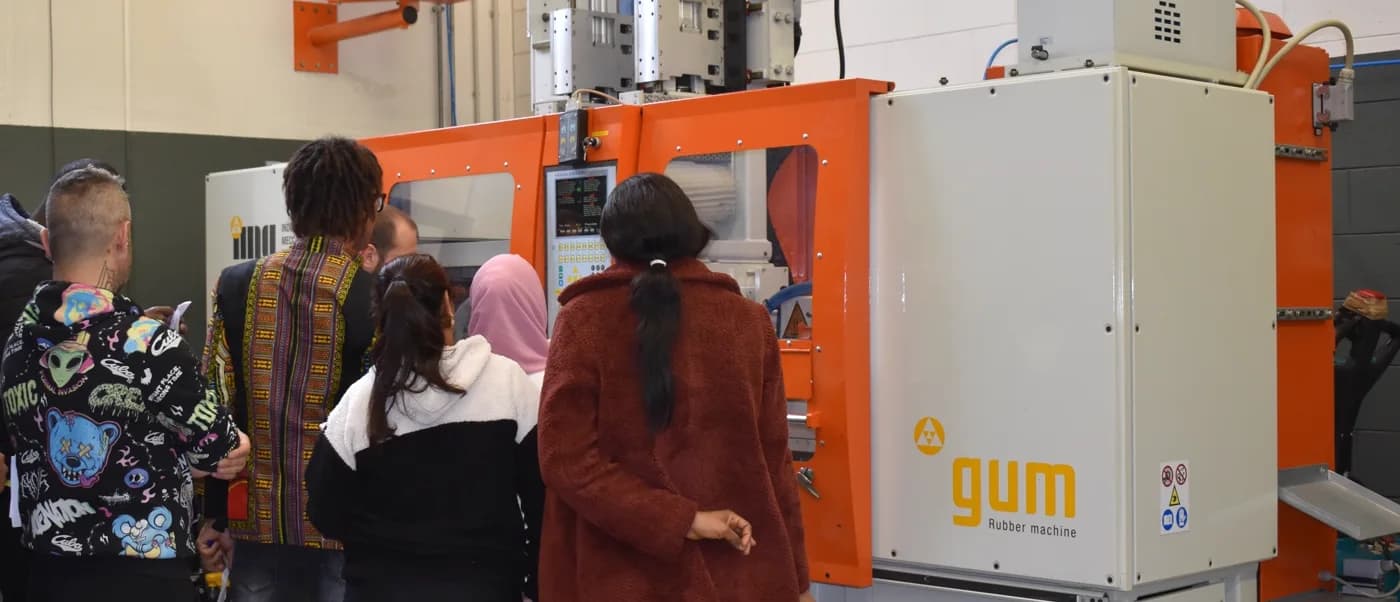 Trainees at an injection molding press