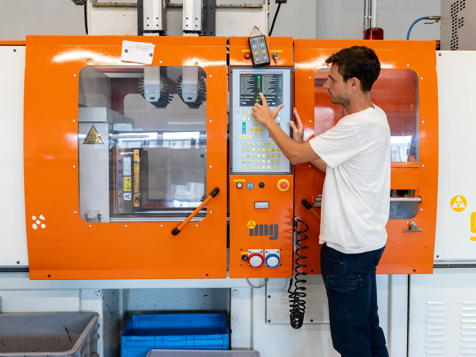 Operator at the control panel of an injection molding press